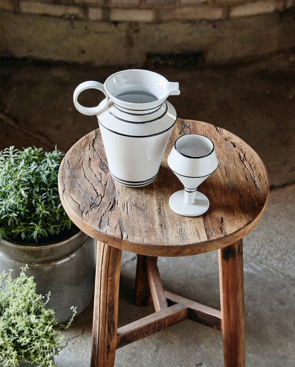 Handgemaakte stoneware kan van Nordal op een gedekte tuintafel
