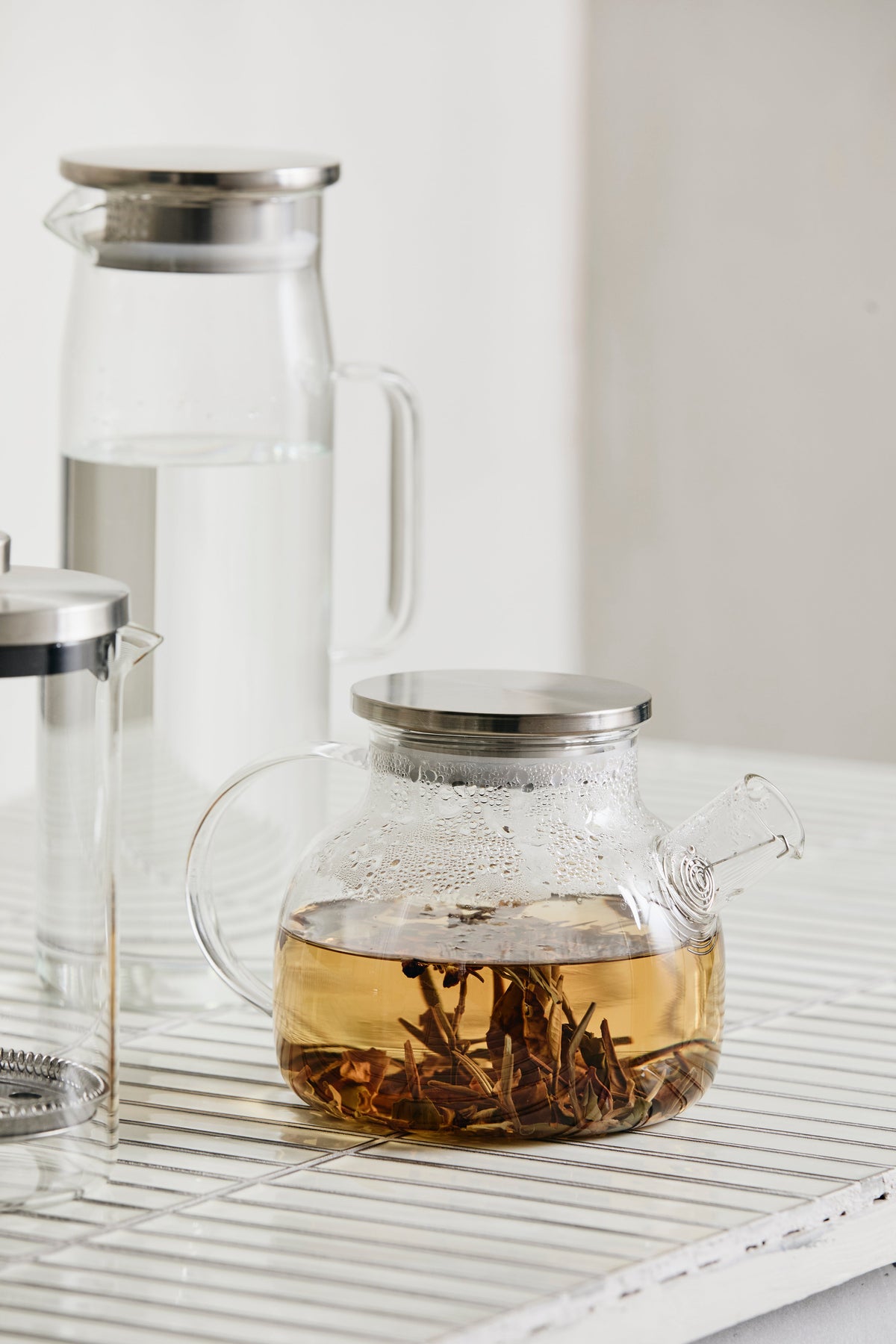 Glazen theepot van Nordal met thee op een gedekte tafel